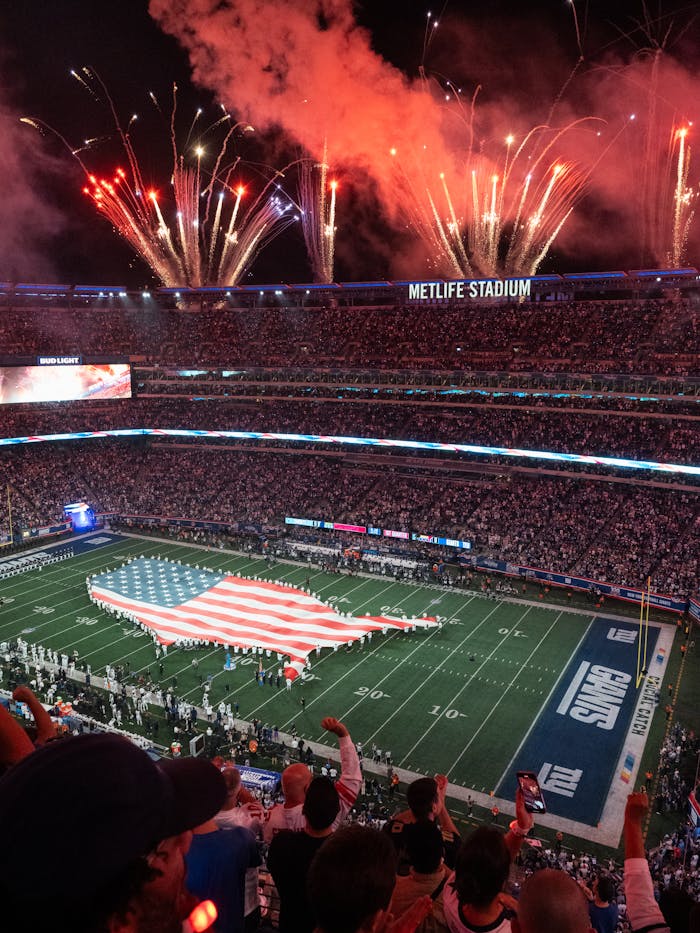 An exciting NFL match day at MetLife Stadium with fireworks and USA flag display.